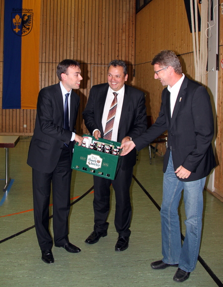 Nils Schmid bekommt von Ortsvorsteher Daniel Steinrode und dem Inhaber der Hochdorfer Kronenbrauerei einen Kasten Bier überreicht